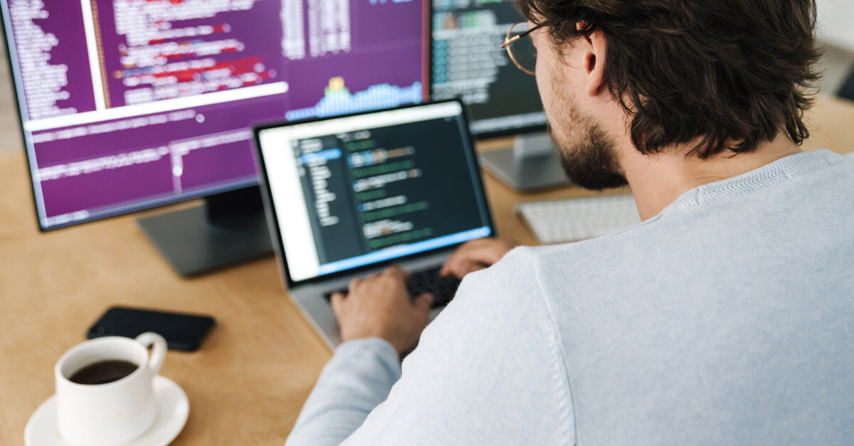 AI programmer writing code on a laptop - iTalent Digital blog