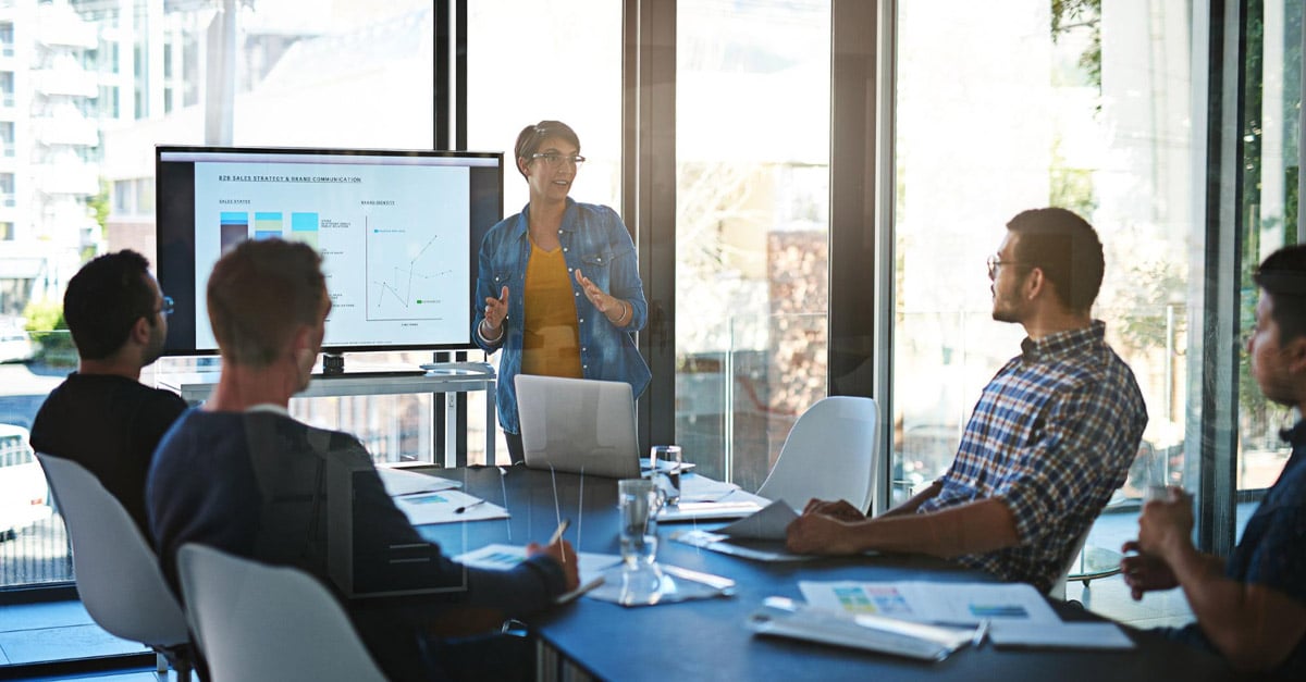senior executive presenting data to colleagues at a conference table - iTalent Digital blog