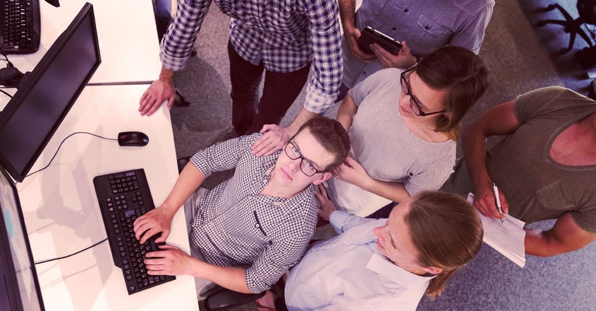 group of people working on a big project in front of a computer monitor - iTalent Digital blog