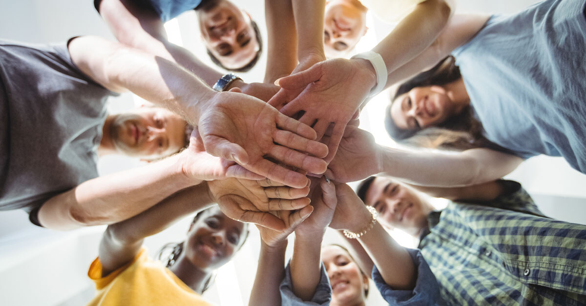 circle of people with their hands touching in the middle - iTalent Digital blog