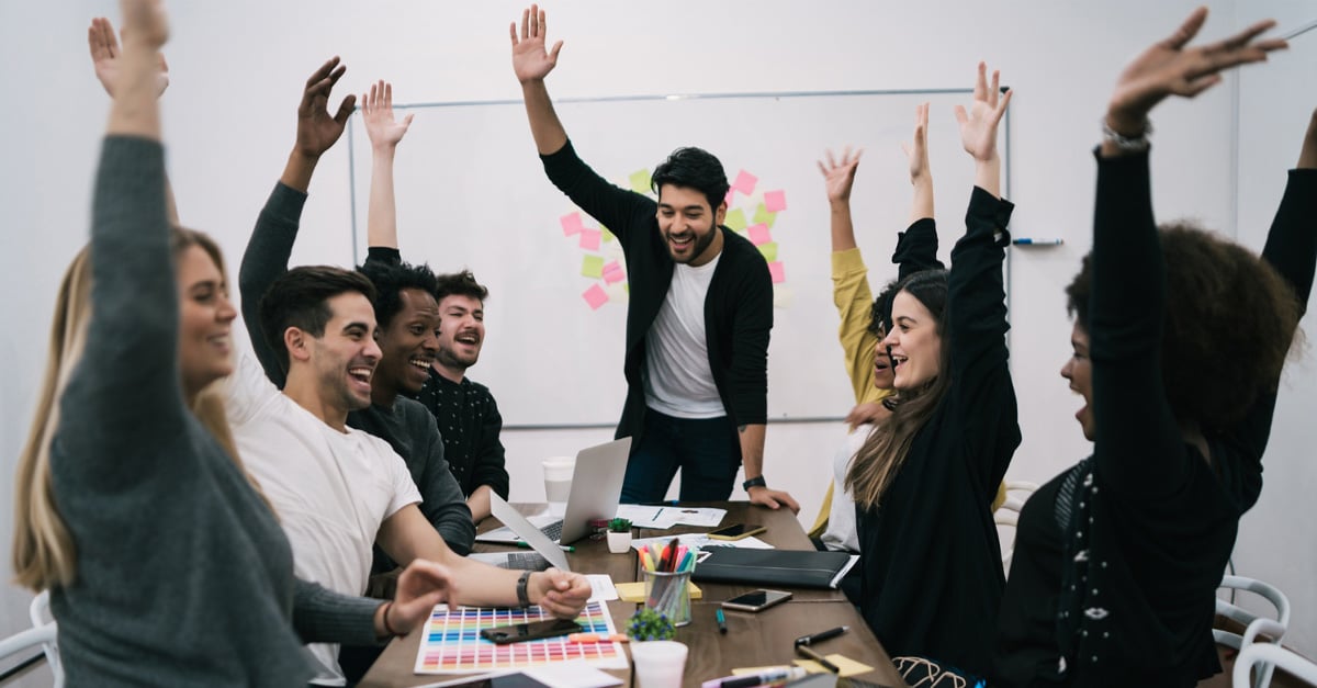 Happy business team celebrating with raised up hands in the office - iTalent Digital blog