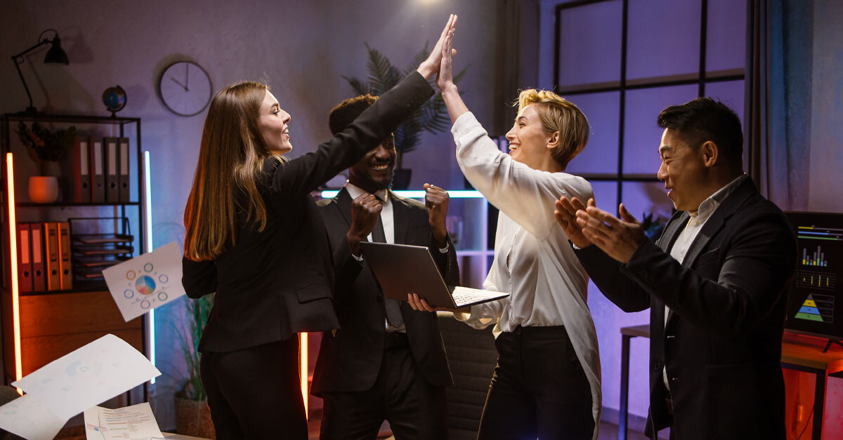 Colleagues in office high-fiving each other - iTalent Digital blog